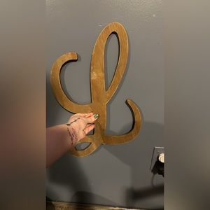 “L” sign. Brown in color. May need painted.